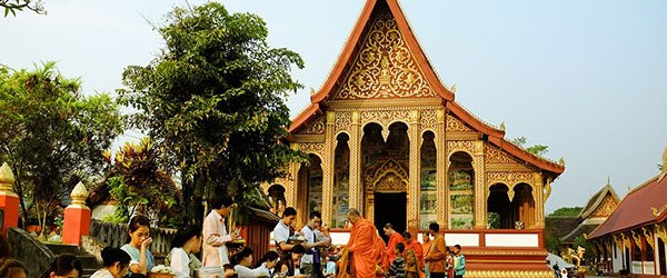 Laotians visit the local temples to make offering to the monks