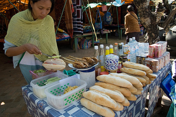A street vendor makes Khao Jii Paté lao cuisine